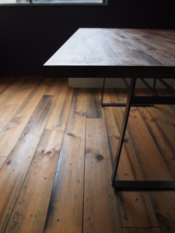 黒皮鉄のテーブルの脚は台形の曲線と、細いラインの棚で構成されています