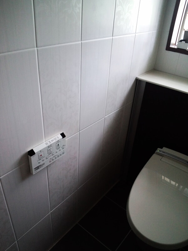 上品な印象の壁タイルと濃いめの床タイルを合わせたトイレ