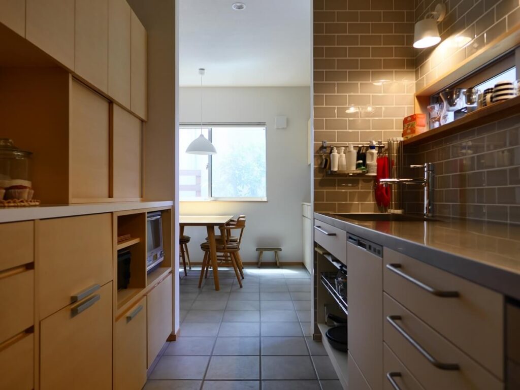 グレータイルの壁と収納たっぷりのキッチン みゆう設計室