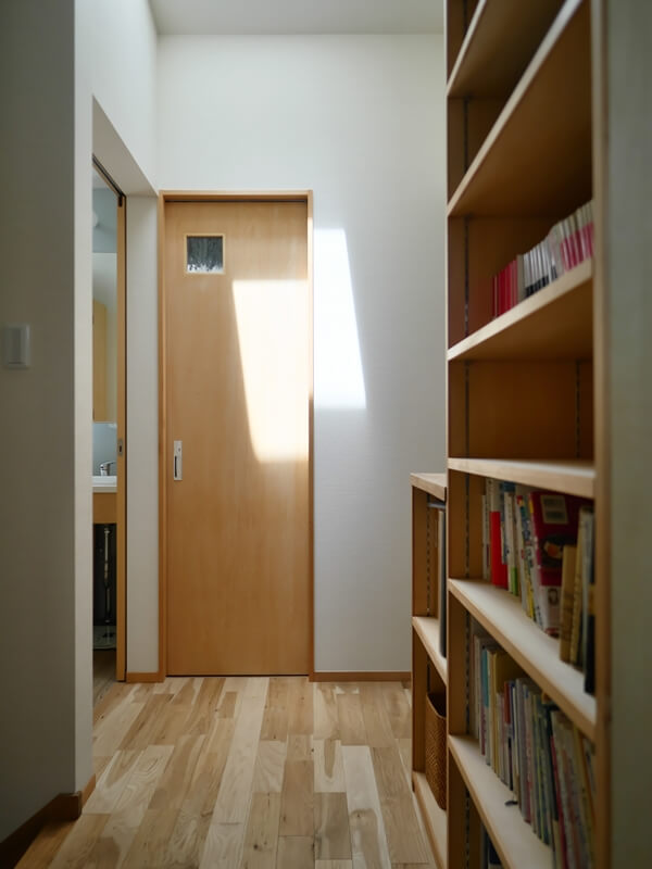 ２階廊下に設けた本棚とシンプルなトイレドア